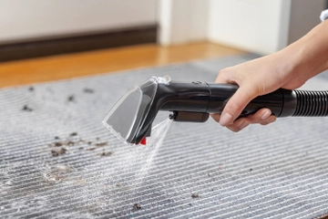 Spraying stain on area rug with 4 inch upholstery tool