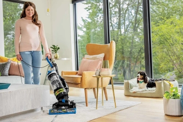 CleanView Swivel Rewind Vacuum vacuuming around furniture. 