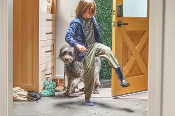 Child and Dog running through door in entry way bringing in mud