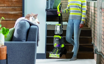 Woman carrying TurboClean PowerBrush Carpet Cleaner down stairs.