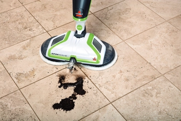 SpinWave Hard Floor Spin Mop spraying wet mess on tile flooring.