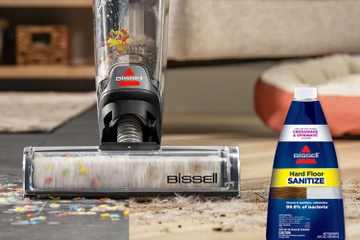 CrossWave OmniForce mopping and vacuuming spill on hard floors and area rug with bottle of Hard Floor Sanitize Formula