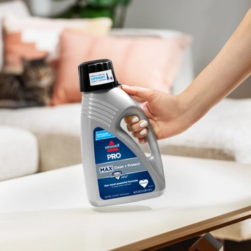 Bottle of PRO MAX Clean + Protect Upright Carpet Cleaning Formula on table.