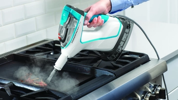 Using Hand Steamer with tool to steam kitchen stove. 