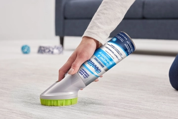 using brush on bottle to scrub carpet