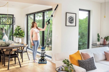 Using extension wand on hose to vacuum above flooring.