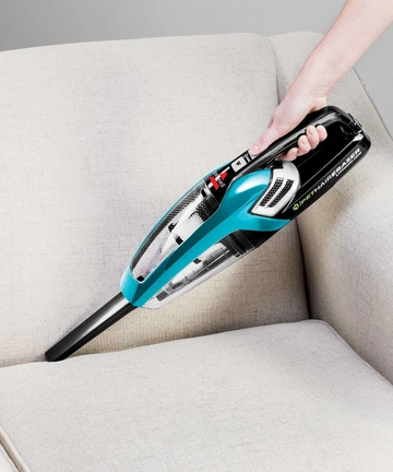 Using Pet Hair Eraser Hand Vac with Crevice Tool to vacuum between couch cushions 