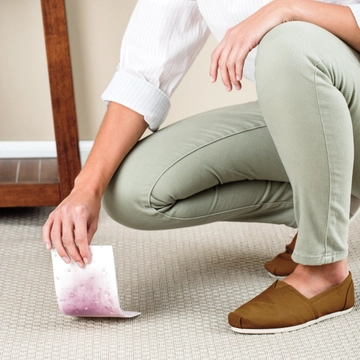 Stomp 'n Go® Pet Stain Lifting Pad being lifted off carpet stain.