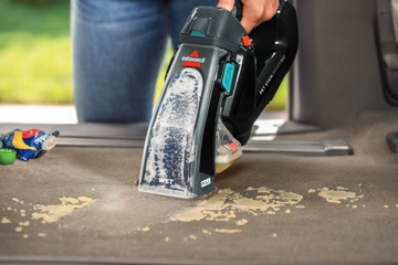 Using Pet Stain Eraser Duo to deep clean spill inside car interior.