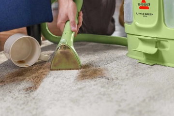 Little Green Mini cleaning coffee spill on carpet