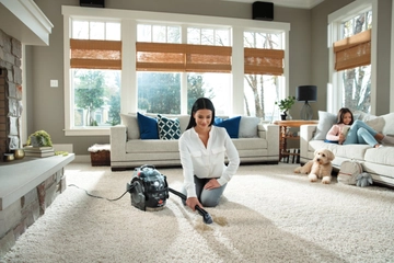 Using SpotClean Pro Portable Carpet Cleaner to clean stain on living room carpet.