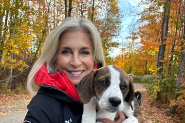 Cathy Bissell holding dog while outside