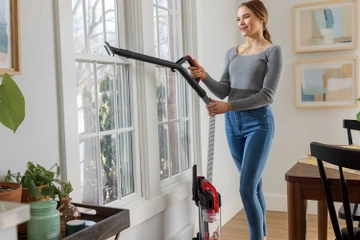 Using Hose with Dusting Brush to vacuum above flooring.