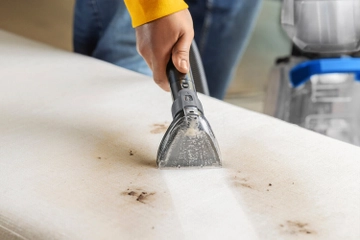 Using Hose and tool to clean dirt from furniture
