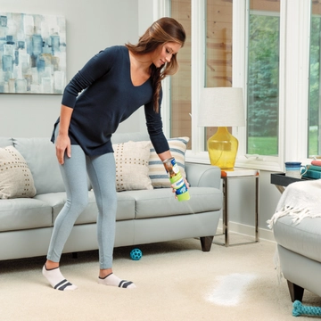 Woolite Heavy Traffic Foam Cleaner being sprayed onto carpet.
