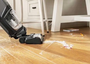 CrossWave HydroSteam Multi-Surface Wet Dry Vac steaming spilled mess on hard flooring.