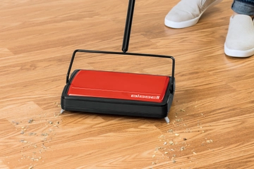 REFRESH Manual Sweeper picking up dirt and crumbs on hard flooring.