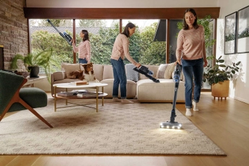 PowerClean FurGuard Stick Vac vacuuming above floors, upholstery, and area rug