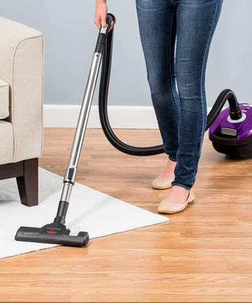 Zing Canister Vacuum Vacuuming area rug and hard flooring.