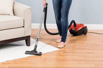 Zing Canister Vacuum Vacuuming area rug and hard flooring.