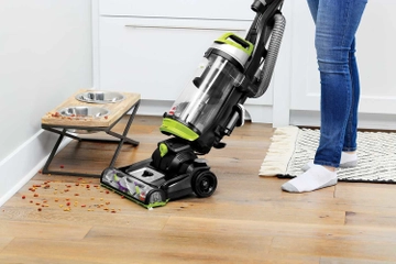 CleanView Swivel Pet Vacuum vacuuming dog food from hard flooring.