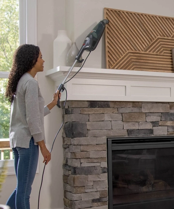 Featherweight Stick Vac vacuuming above flooring. 