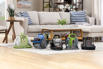 BISSELL portable deep cleaners on area rug in living room.