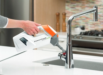 Using Handheld steamer to steam clean kitchen sink.