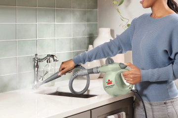 Using Steam Shot OmniForce Handheld Steamer to steam kitchen sink