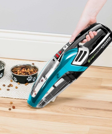 Pet Hair Eraser Hand Vac vacuuming pet food from flooring