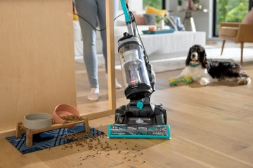 CleanView Swivel Pet Reach Vacuum vacuuming dog food around cabnet.