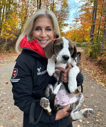 Cathy Bissell holding dog while outside