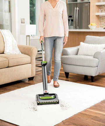 Using AirRam Cordless Vacuum to vacuum dirt from area rug