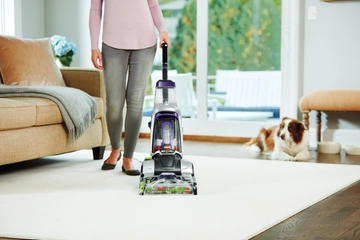 Using ProHeat 2X Revolution Pet Pro carpet cleaner to deep clean area rug with dog nearby.