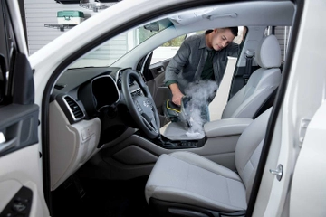 Using handheld steamer to clean interior of vehicle