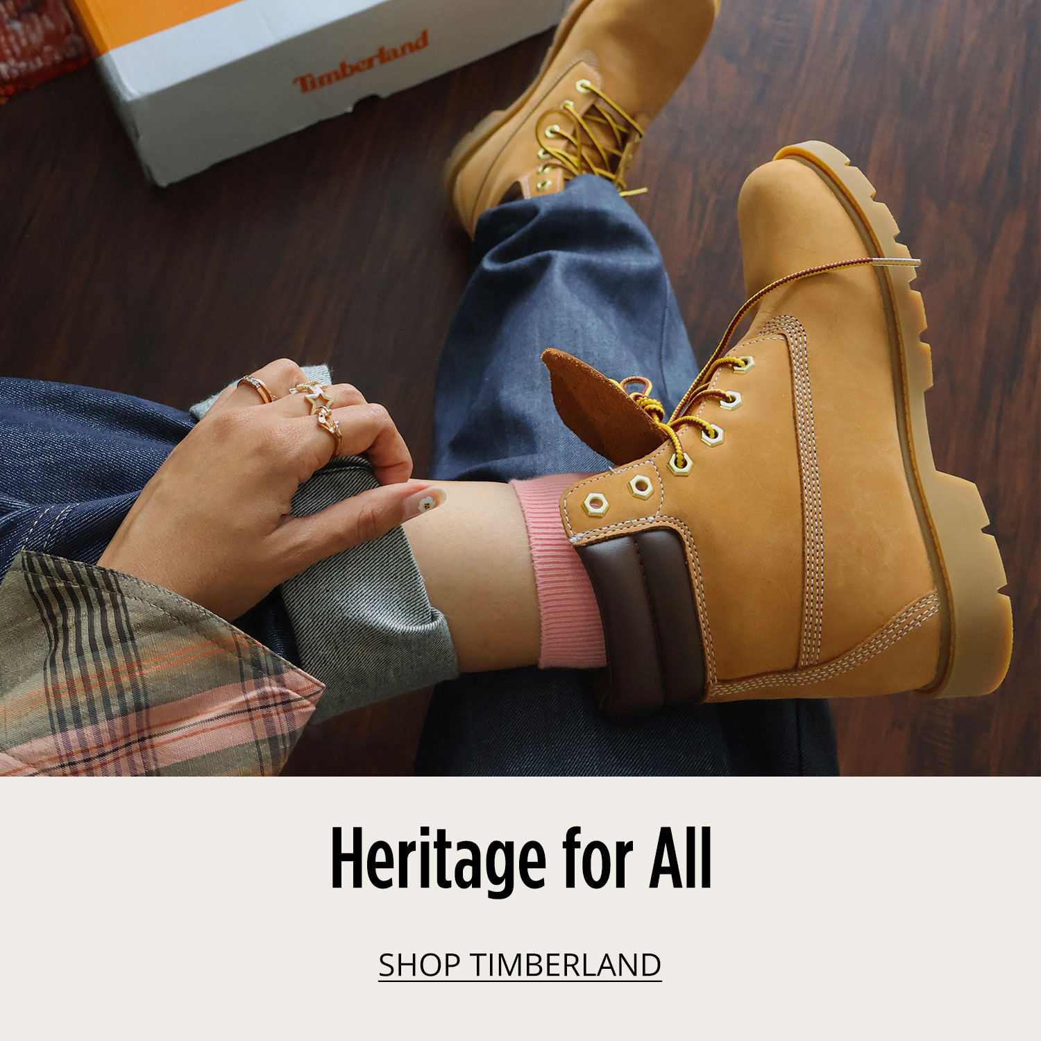 Woman in classic yellow Timberland boots displayed with Timberland shoe box in background			
