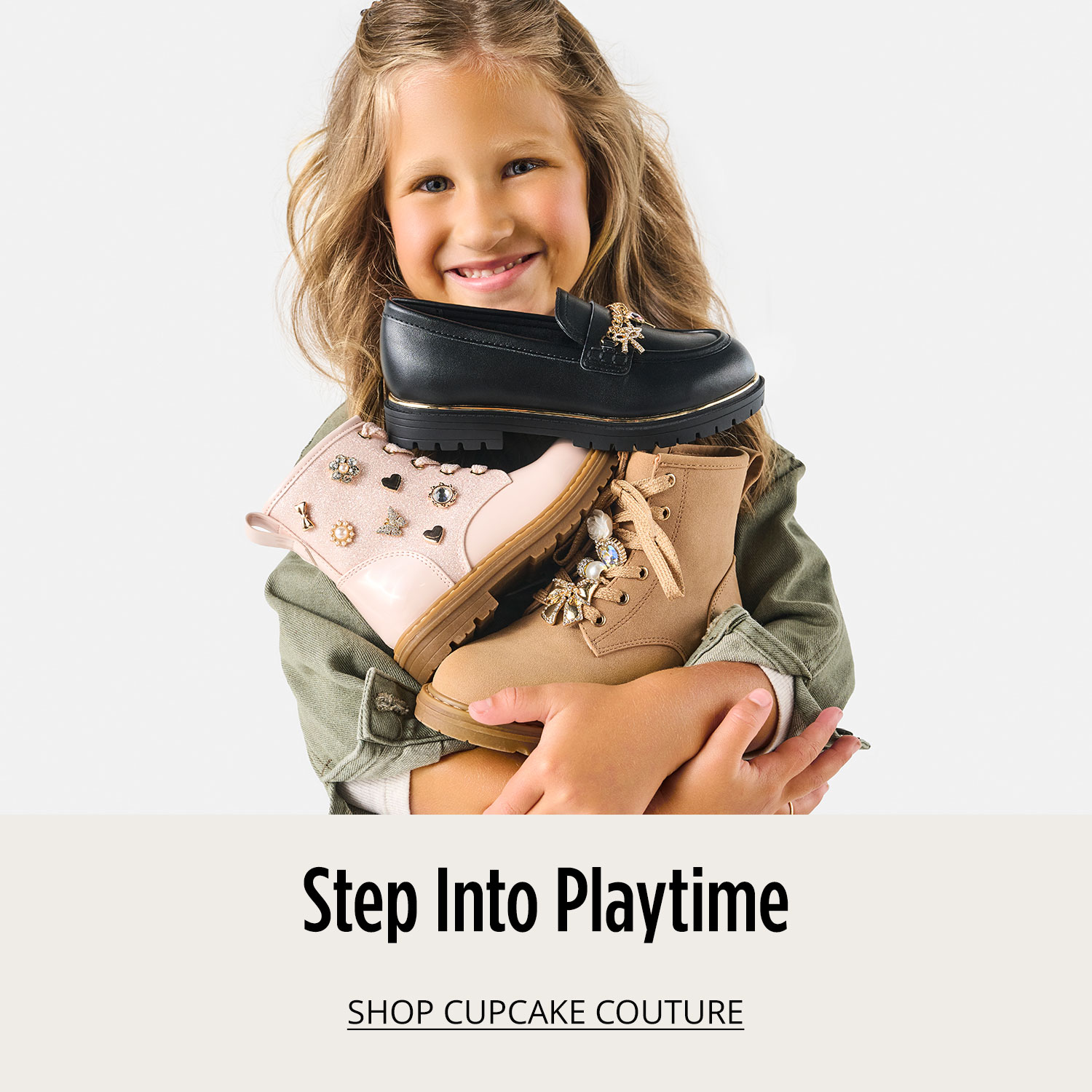 Little girl holding an armful of shoes