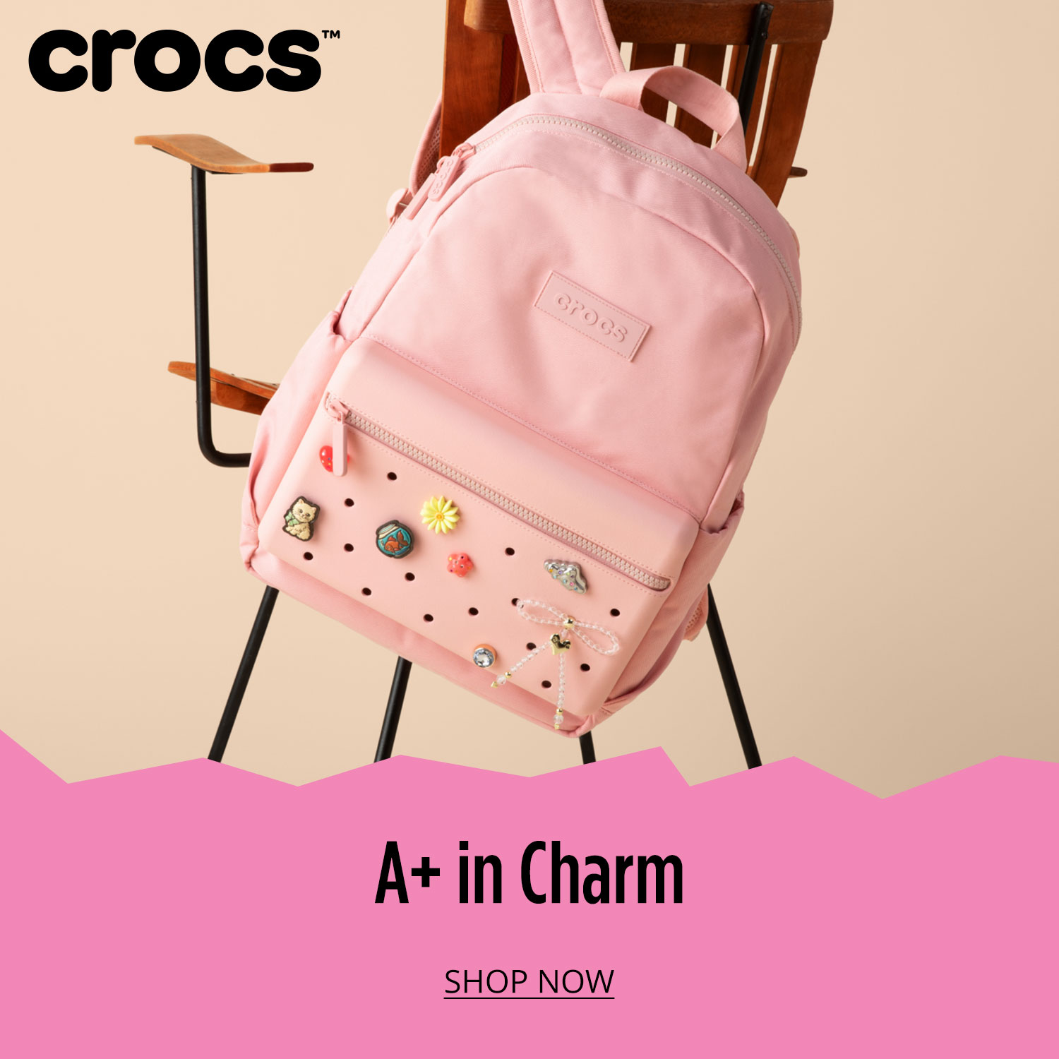 Light pink Crocs backpack hanging on chair from one side			