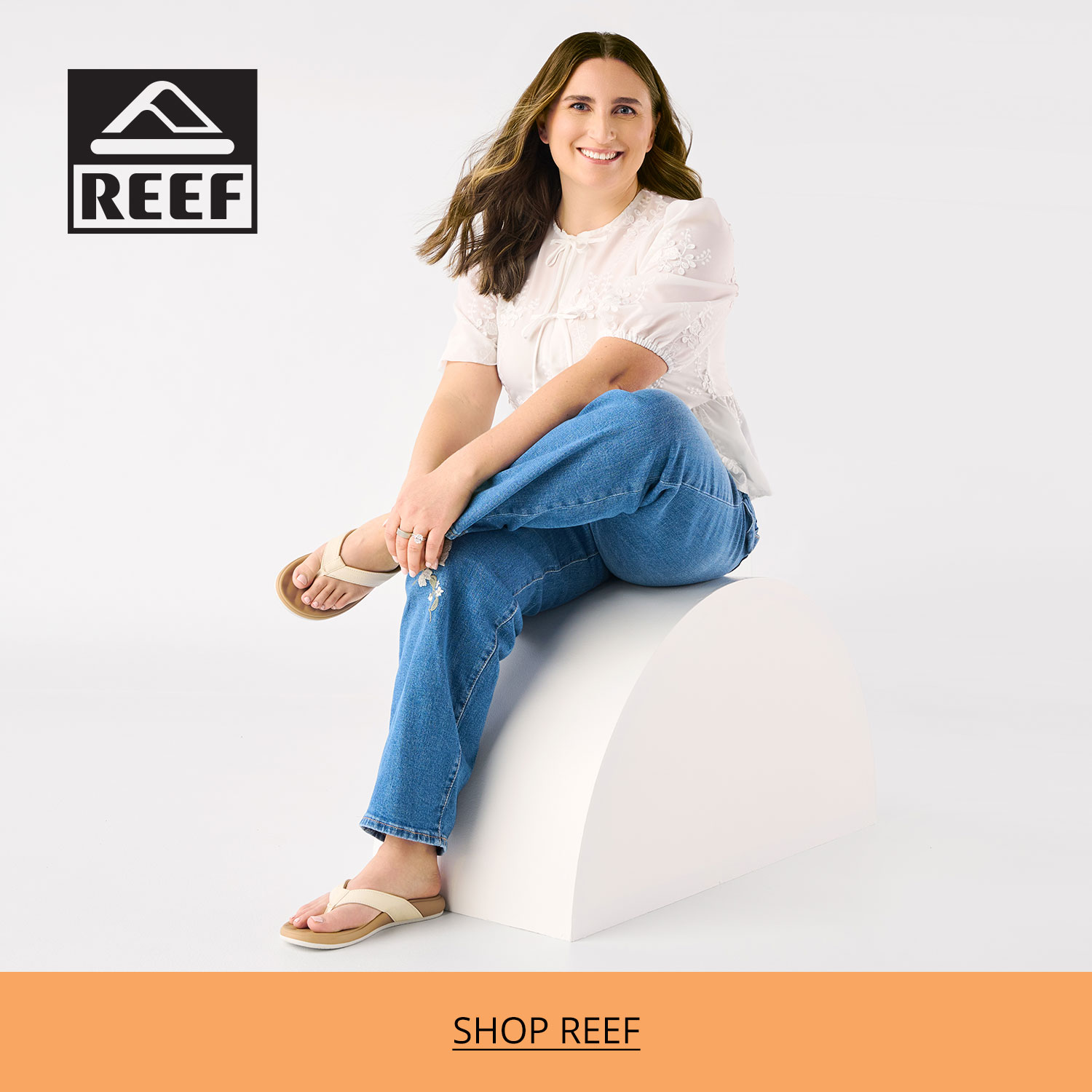 An on the go mom ready for some relaxation time at the beach sitting on a plinth wearing her favorite Reef flip flops.