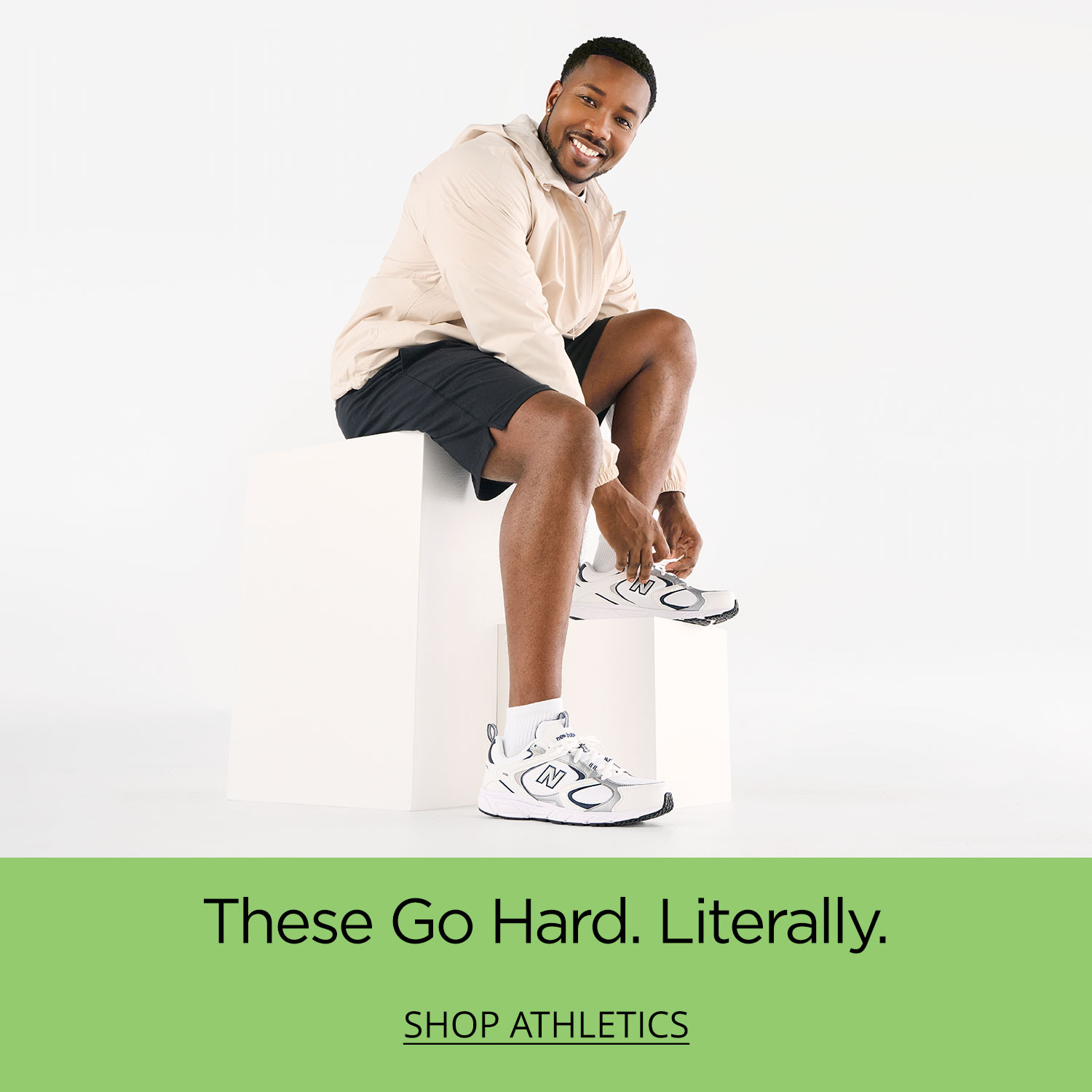 An active dad getting his New Balance sneakers all tied up while sitting on a white plinth.