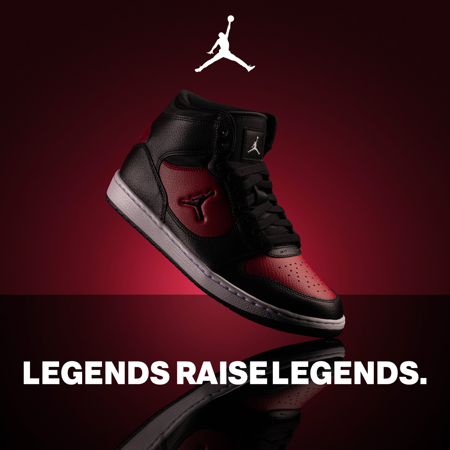 A right side shot of the Black and Red Jordan Court Connect on a black and red glow background with it's mirrored image on the floor with text saying Legends Raise Legends. Jordan logo at top of image.