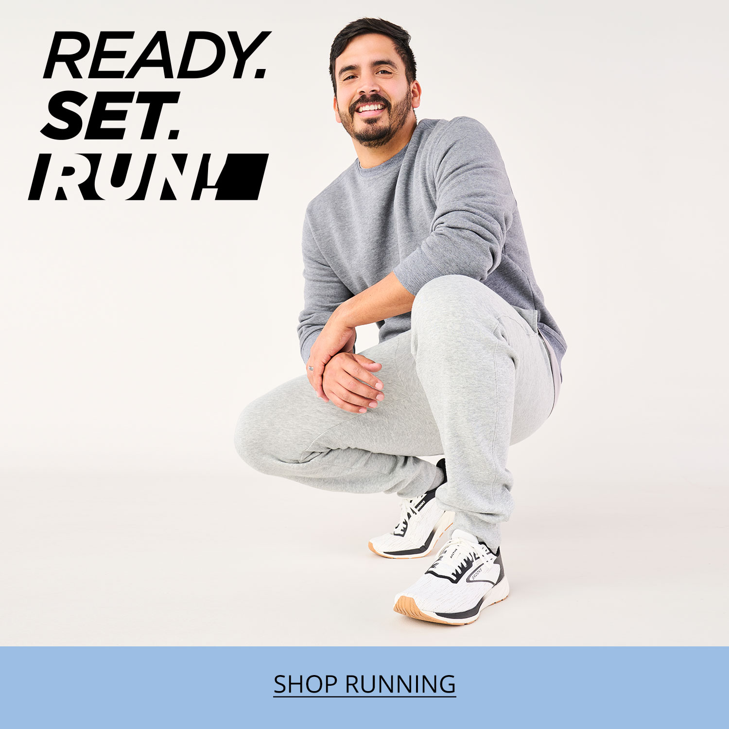 A dad crouching forward, smiling and showing off his new Brooks Anthem 7 running shoes.