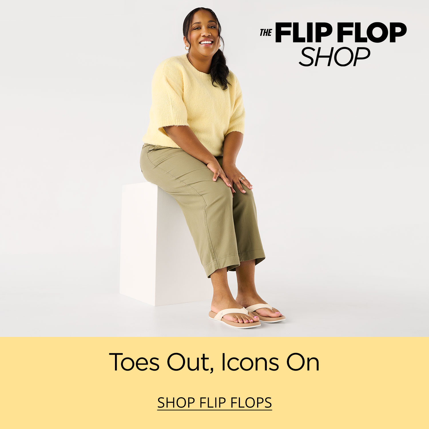 A woman sitting on a plinth wearing stylish casual clothes and comfortable Reef Cushion Harmony flip flops.
