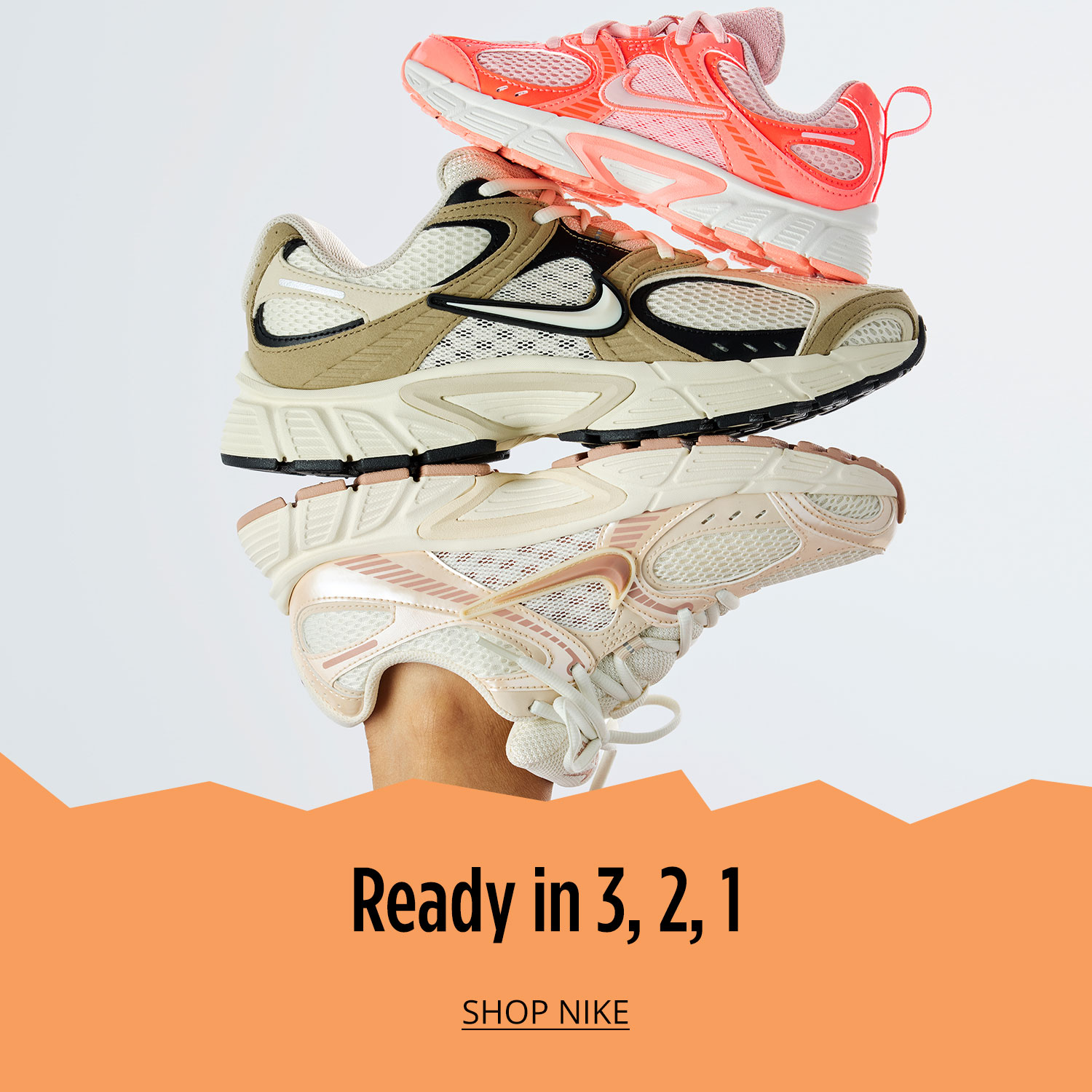 Three classic athletic sneakers from Nike for whole family are stack on top of each other on white background.