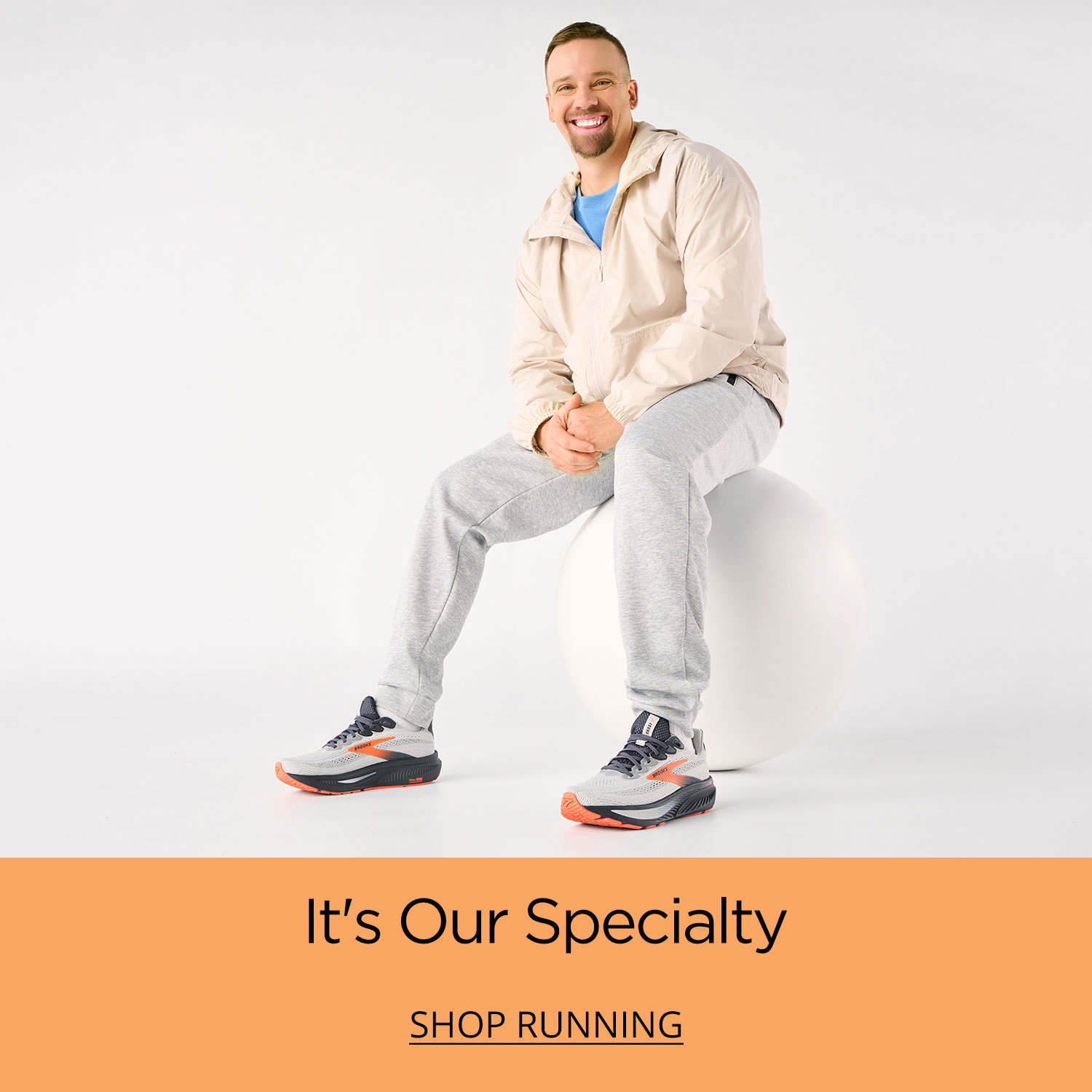 An active dad sitting on a plinth about to get started on his warm up run wearing his go-to running shoes.