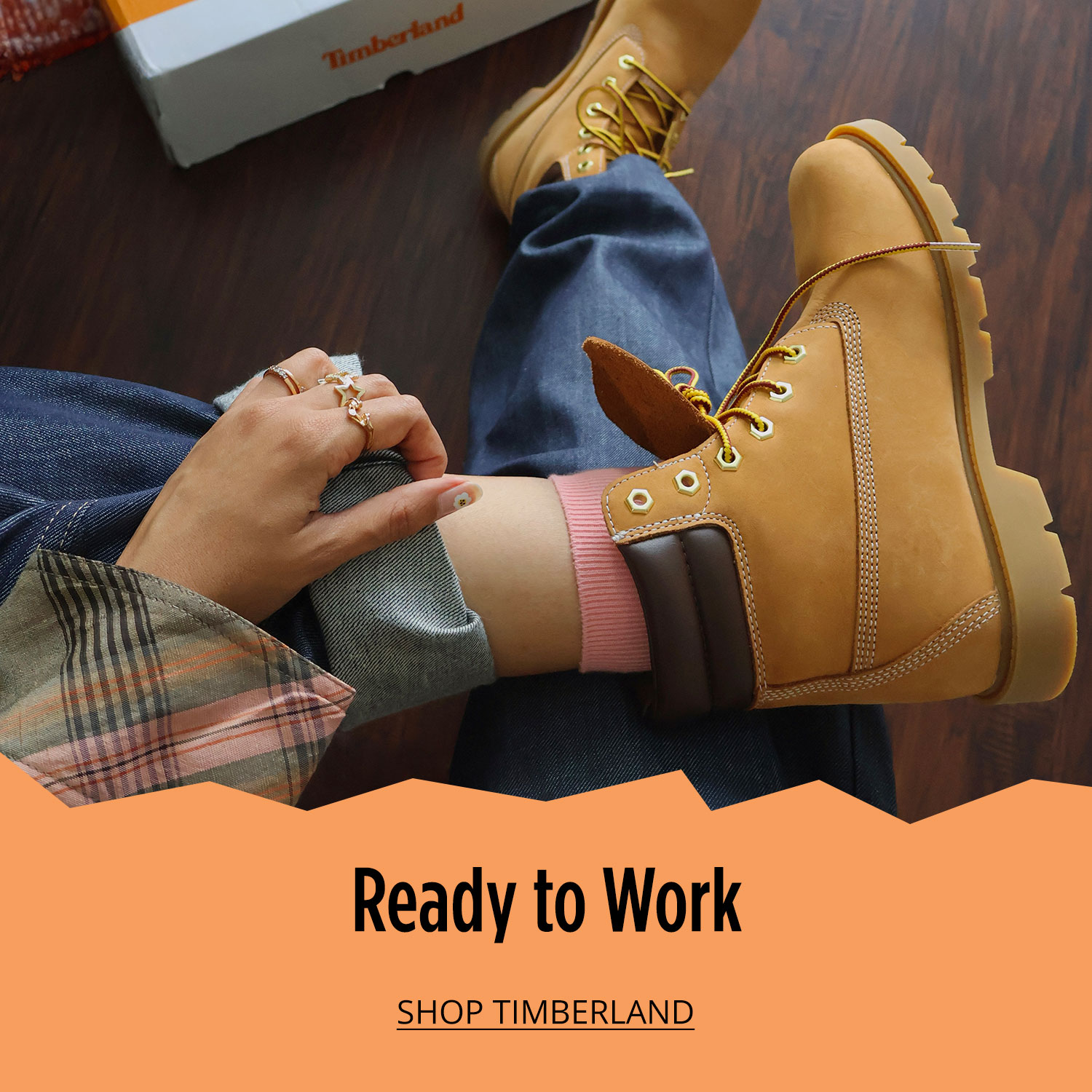 Woman in classic yellow Timberland boots displayed with Timberland shoe box in background			