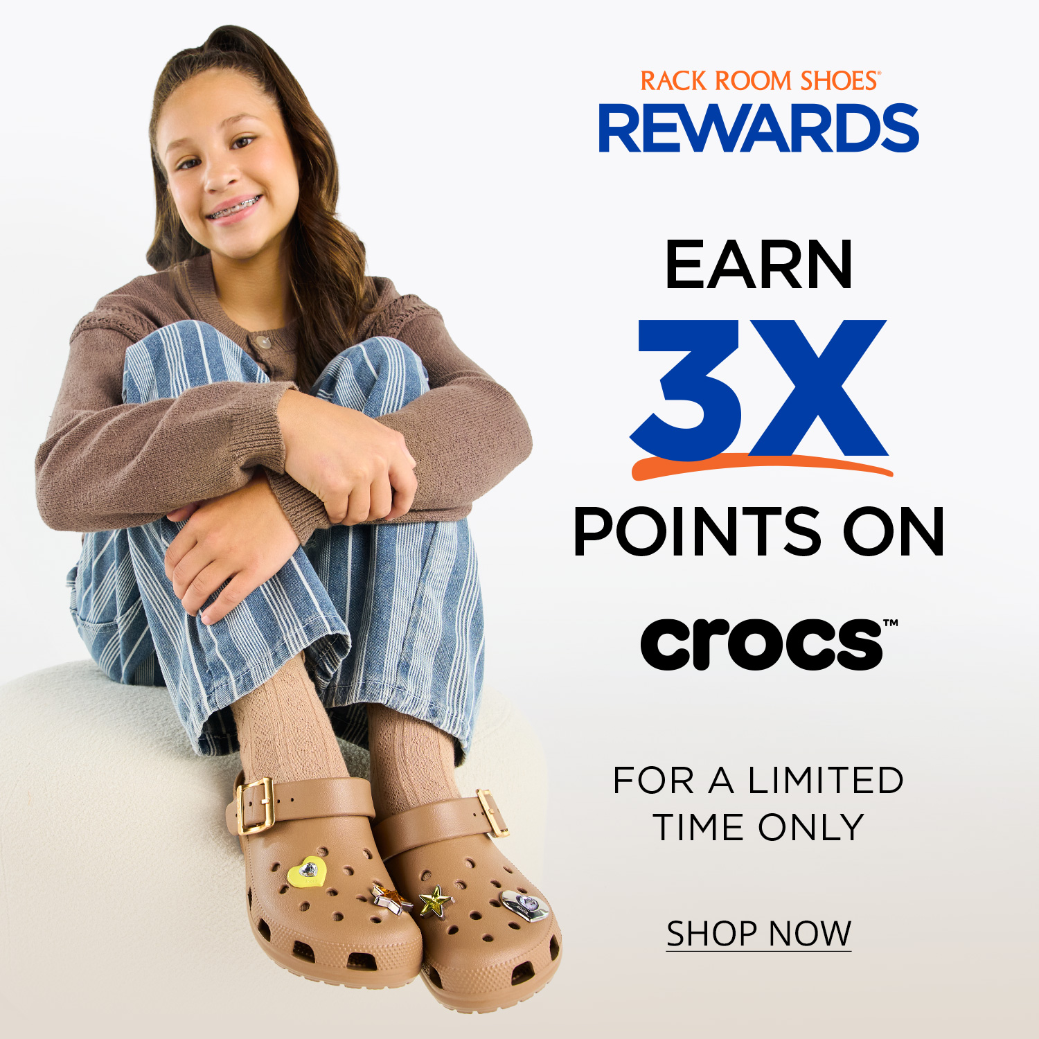 Young person sitting with legs pulled to chest wear tan Crocs clogs decorated with Jibbitz. Text on image says Rack Room Shoes Rewards. Earn 3X Points on Crocs for a limited time only.