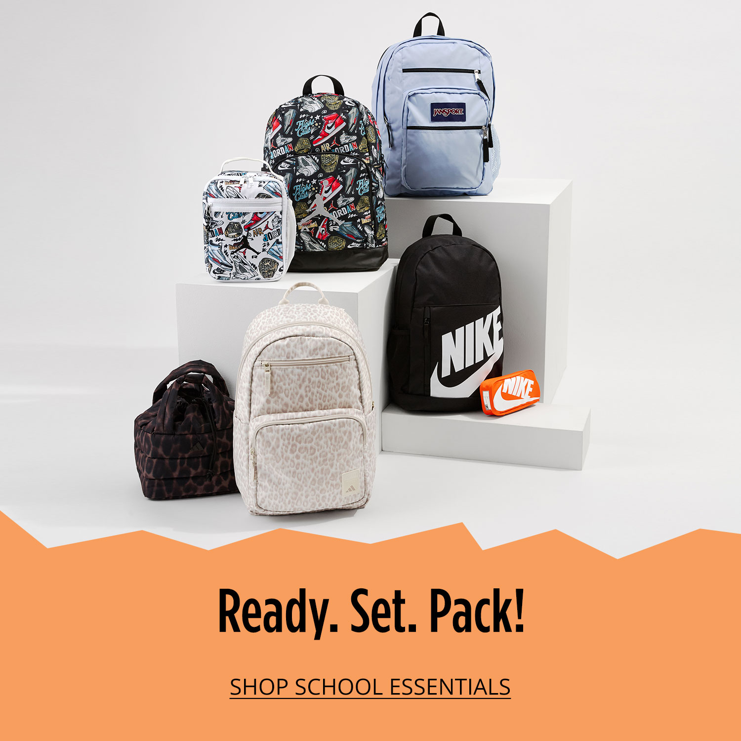 Six backpacks displayed on white plinth and floor at varying heights