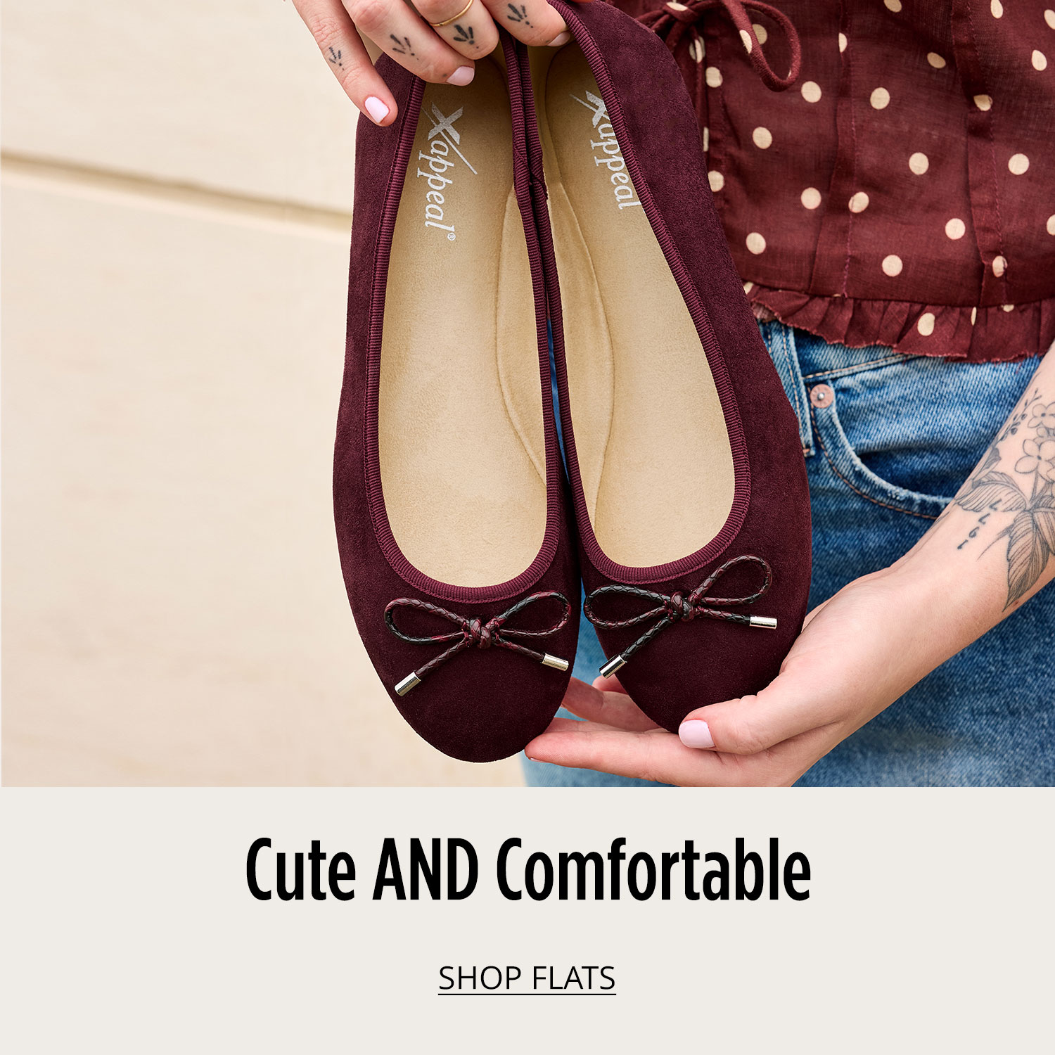 Woman holding a pair of ballet flats and showing off her tattoos