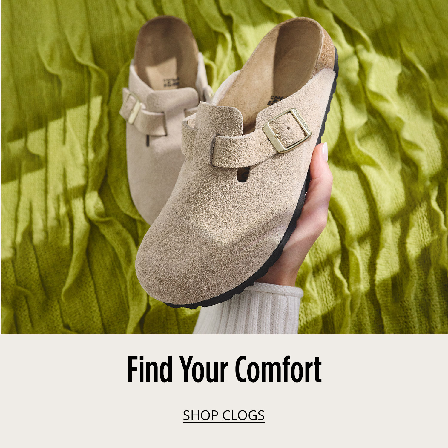 Woman's hand holding one comfortable clog from a pair in focus